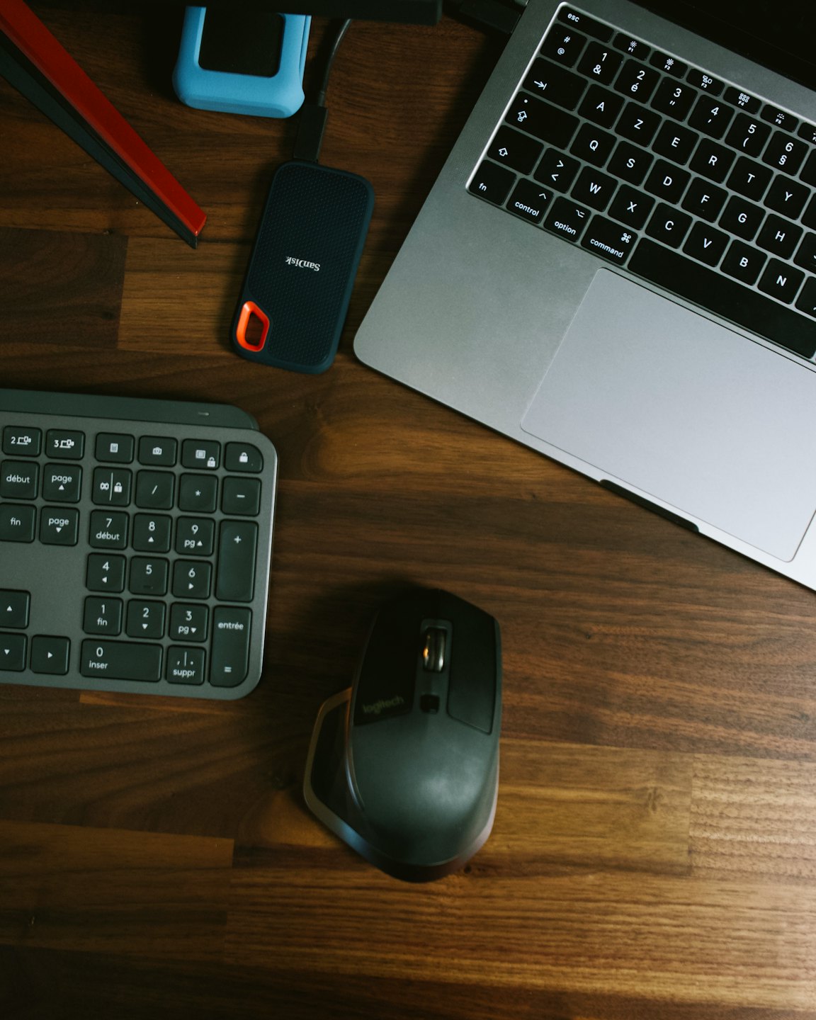Laptop and office accessories arranged on a wooden desk.